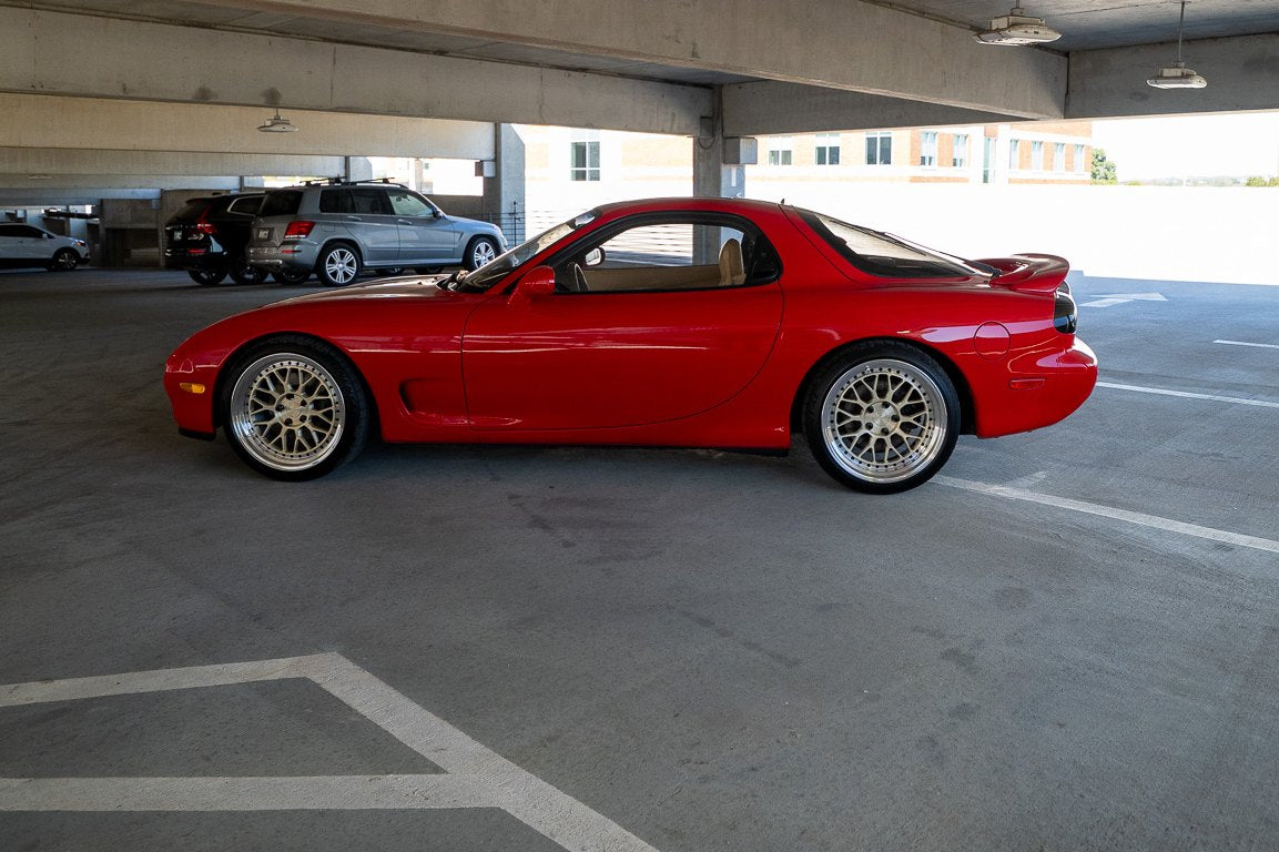 Red RX-7 FD side profile in a parking garage