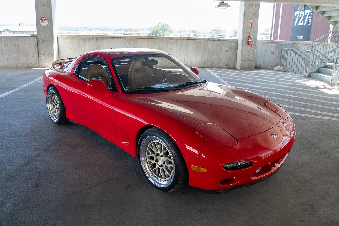 Red RX-7 FD three-quarter view in a parking garage
