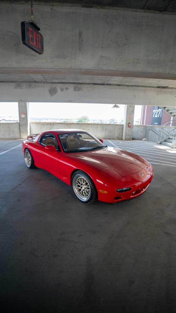 Red RX-7 inside a concrete parking structure