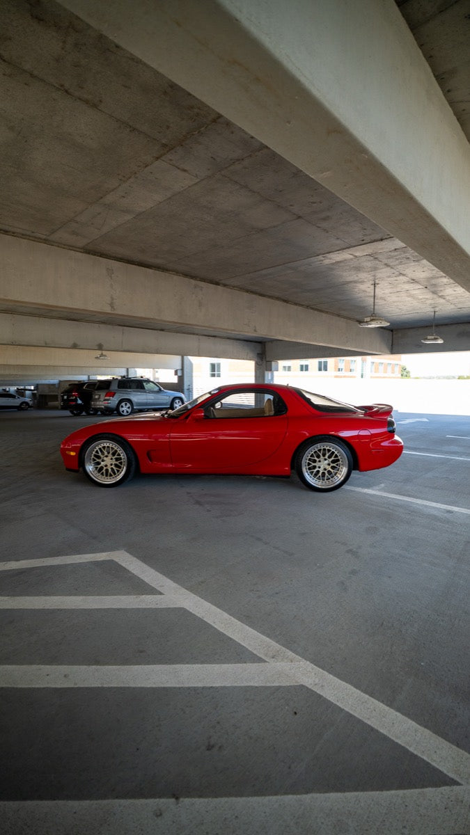Side view of the red RX-7 inside a parking structure