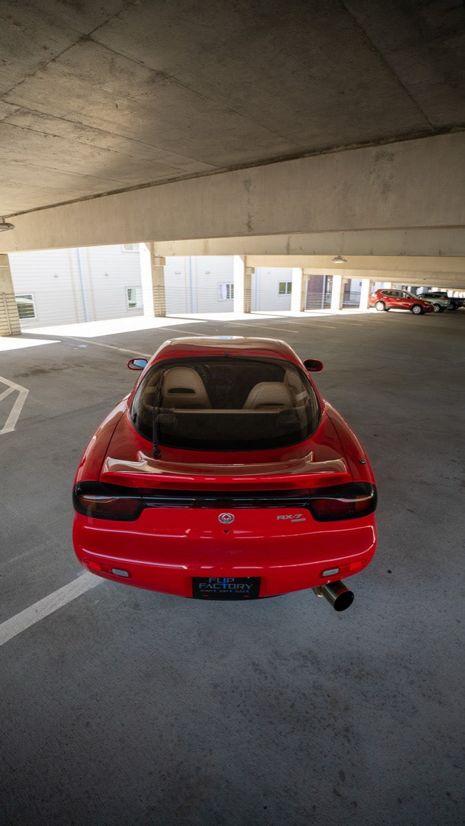 Rear view of the red RX-7 inside a parking structure