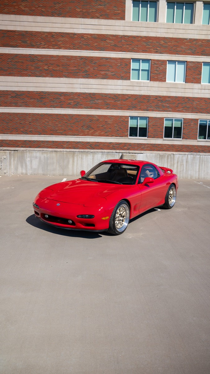 Front three-quarter view of the Vintage Red 1993 Mazda RX-7 on gold BC Racing mesh wheels